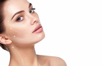 Woman with clear skin tilts her head back; white arrows on her face and neck indicate directions for cosmetic or lifting procedures against a white background.