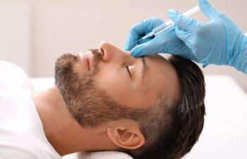 Side view of middle-aged man getting beauty injection in nose at aesthetic clinic.