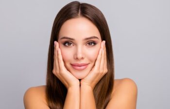 face of a beautiful young-looking woman touching skin on her cheeks