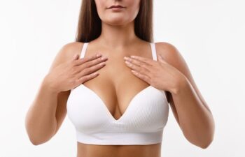 A mature woman with full breasts wearing a white bra