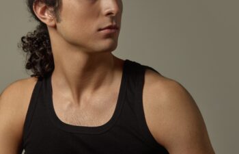 Close-up cropped image of male face, neck and jawline with strong bone structure, smooth hydrated skin against neutral background. Concept of skincare, men beauty, self-care, confidence